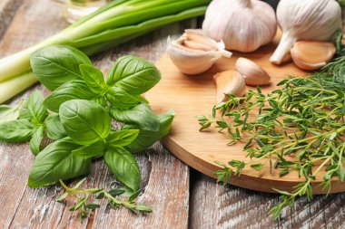 Farklı taze otlar ve baharatlar ahşap masada, yakın plan.