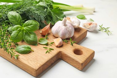 Beyaz masada farklı taze otlar ve baharatlar, yakın plan.