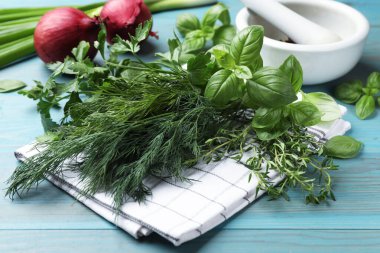 Mavi ahşap masada farklı otlar ve baharatlar, yakın plan.