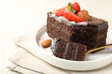 Masada çilekli ve bademli bir dilim lezzetli çikolatalı pasta, yakın plan. Metin için boşluk