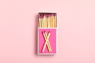 Pembe arkaplanda kibrit ve kutu, üst görünüm