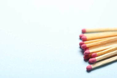 Açık arkaplanda pembe başlıklı kibritler, yakın plan. Metin için boşluk