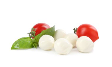Beyaz arka planda lezzetli mozzarella peynir topları, domates ve fesleğen.
