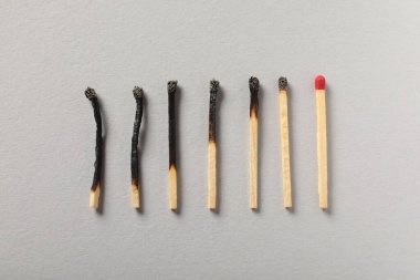 Gri arka planda yanmış ve bütün kibritler düz yatıyordu.