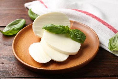 Lezzetli mozzarella ve fesleğen ahşap masada, yakın plan.