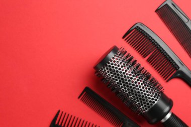 Kırmızı arka planda farklı kuaför aletleri var. Metin için boşluk