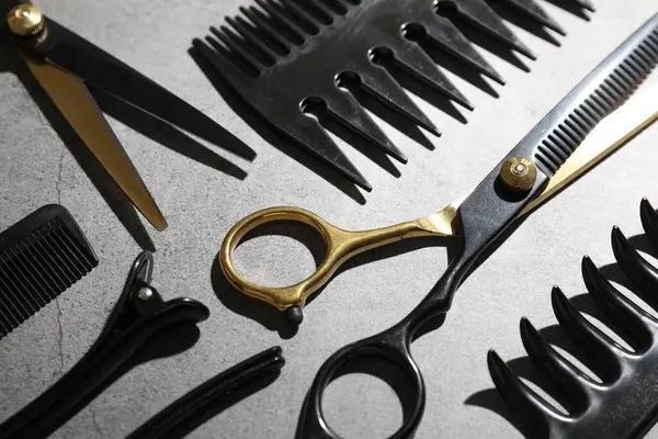 Gri masadaki farklı kuaför aletleri, yakın plan.