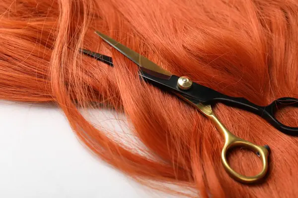 Hafif arkaplanda saç teli ve makas, yakın plan.