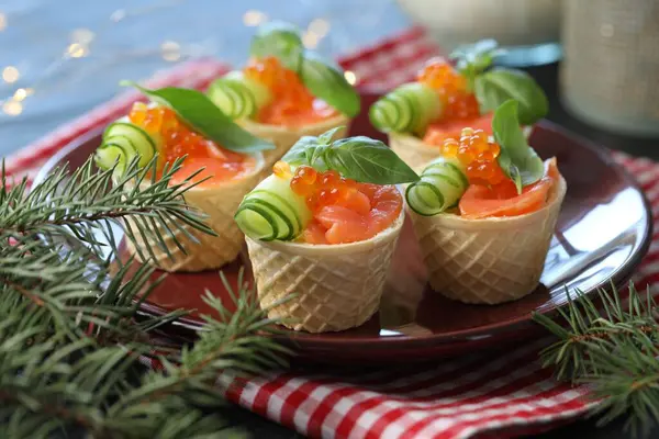 Lezzetli kanepeler ve köknar dalları masada, yakın plan.