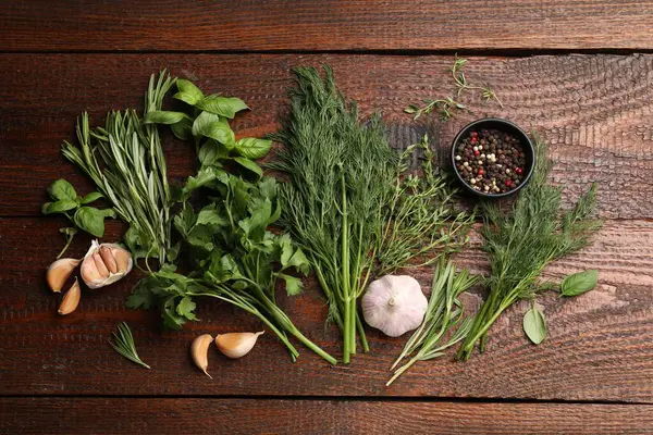 Farklı taze otlar ve baharatlar ahşap masada, düz yatıyordu.