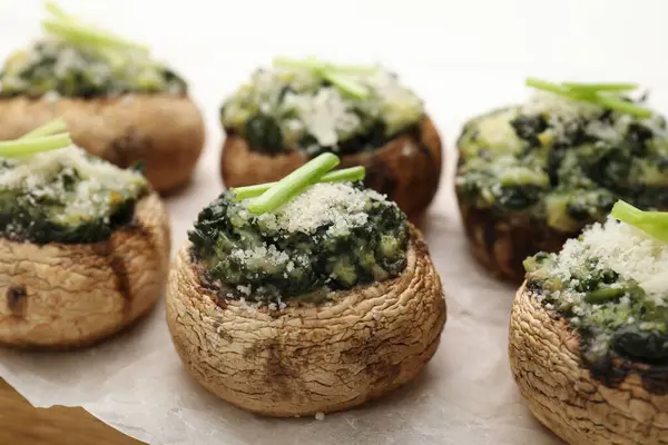 Beyaz ahşap masada servis edilen lezzetli mantarlar, yakın plan.