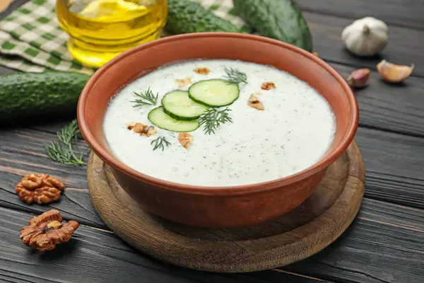 Dereotlu salatalık çorbası, ceviz ve ahşap masa malzemeleri, yakın plan.