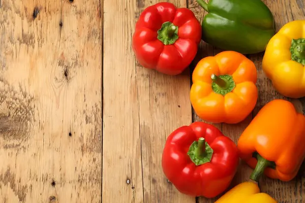 Tahta masada taze, renkli dolmalık biberler, düz uzanmış. Metin için boşluk