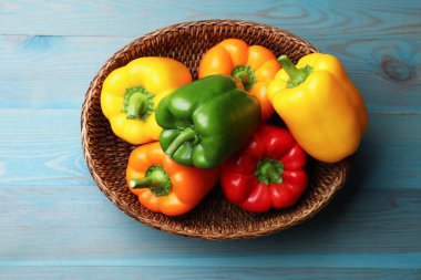 Mavi ahşap masada taze dolmalık biberler, üst manzara.