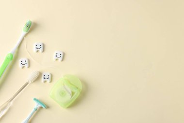 Bej arka planda farklı oral bakım ürünleri ve diş modelleri var. Metin için boşluk