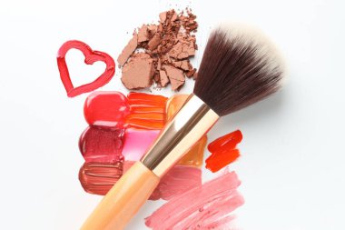 Beyaz arka planda farklı kozmetik ürünleri ve makyaj fırçası, düz konum