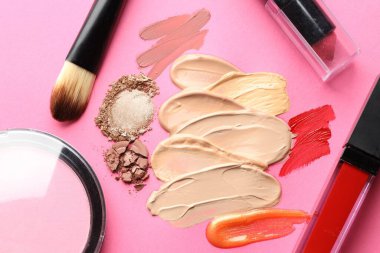 Eflatun arka planda farklı kozmetik ürünler ve makyaj fırçaları, düz yatış