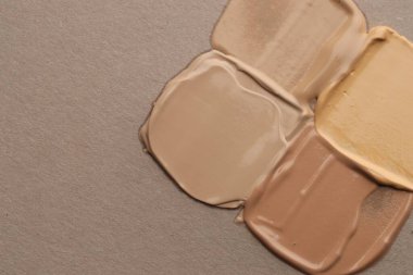 Gri arka planda, düz zeminde renkli cilt temelleri. Metin için boşluk