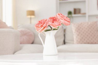 Beyaz masadaki güzel çiçekli vazo kapalı, yakın plan.