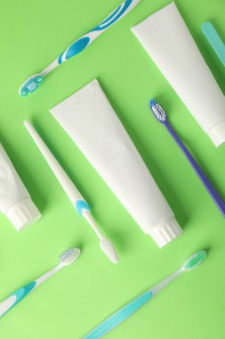 Yeşil zemin üzerinde diş fırçası ve tüpler düz yatıyordu.