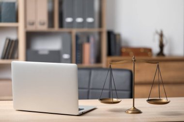 Ofisteki ahşap masada adalet ve dizüstü bilgisayar terazileri.