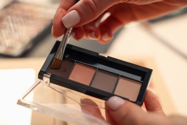 Makyaj masasında fırça ve göz falı olan kadın, yakın plan.