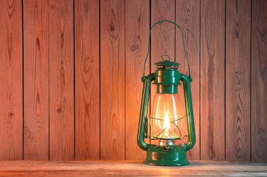 Ahşap masada eski bir gaz lambası, metin için yer var.