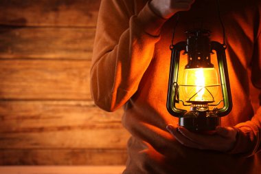 Ahşap arka planda klasik gaz lambası olan adam, yakın plan. Metin için boşluk