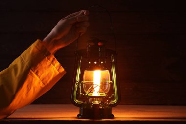 Ahşap arka planda klasik gaz lambası olan adam, yakın plan.