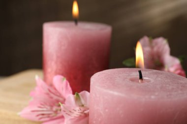 Yanan mumlar ve zambak çiçekleri masada, yakın plan.