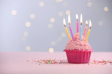 Kekin içinde mum yakmak ve bulanık ışıklara karşı masaya serpiştirmek. Metin için boşluk