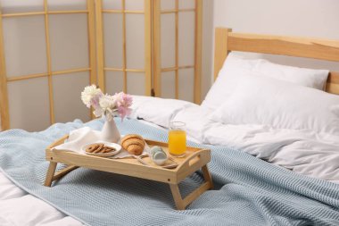 Nefis bir kahvaltı tepsisi ve kapalı bir odada çiçekler.