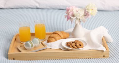 Nefis bir kahvaltı tepsisi ve çiçeklerle kapalı bir yerde, yakın plan.