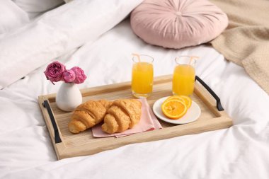 Nefis bir kahvaltı tepsisi ve çiçeklerle kapalı bir yerde, yakın plan.