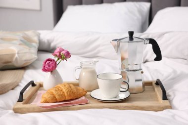 Nefis bir kahvaltı tepsisi ve çiçeklerle kapalı bir yerde, yakın plan.