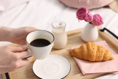 Kadın yatakta nefis bir kahvaltı yapıyor, yakın plan.