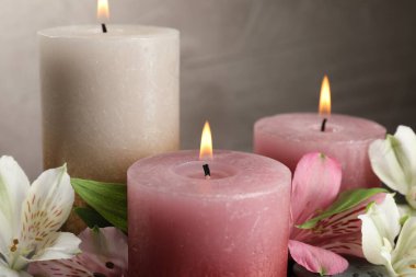 Yakıcı mumlar ve güzel çiçekler arka planda, yakın plan