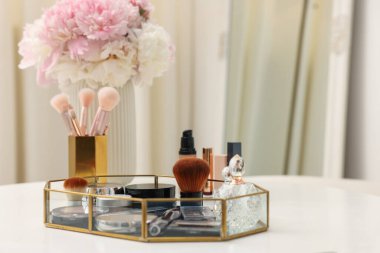 Beyaz masadaki farklı makyaj ürünlerinin olduğu tepsi. Metin için boşluk