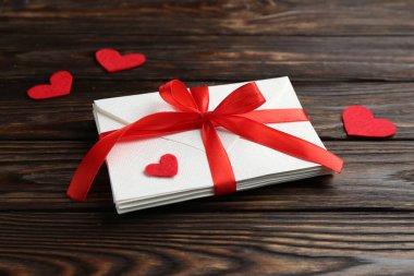 Aşk mektupları ve kırmızı kalpler ahşap masada, yakın plan.