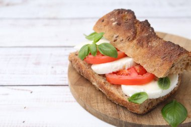 Mozarella peynirli, domatesli, fesleğenli, beyaz ahşap masa, yakın plan. Metin için boşluk