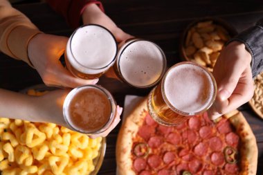 Bira ve atıştırmalık arkadaşlar ahşap masada, manzaralı.