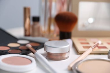 Beyaz masada farklı makyaj ürünleri, kapalı masa, yakın çekim.