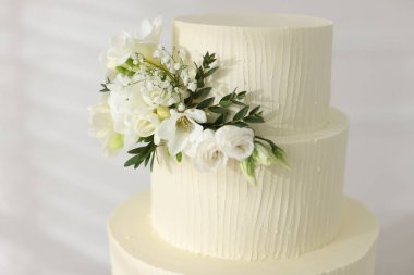 Çiçeklerle süslenmiş nefis düğün pastası, yakın plan.