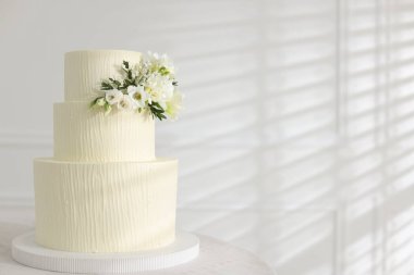 İçerideki masada çiçek desenli nefis düğün pastası, mesaj için yer var.