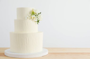 Ahşap masa üzerinde çiçek desenli nefis düğün pastası beyaz arka plan, metin için yer