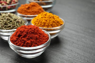 Gri masada farklı aromatik baharatlar, yakın plan.