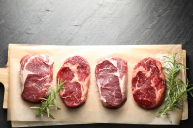 Çiğ et parçaları, biberiye ve siyah masaya tuz, üst manzara. Metin için boşluk