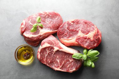 Çiğ et parçaları ve baharatlar gri masada, düz yatıyordu.