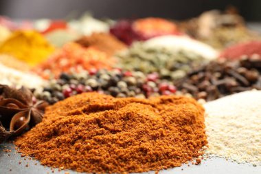 Gri masada farklı aromatik baharatlar, yakın plan.