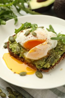 Avokadolu lezzetli sandviç, haşlanmış yumurta, roka ve balkabağı, yakın plan.